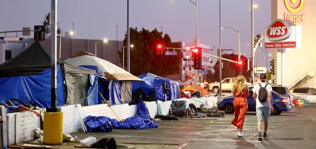 People walk past a homeless encampment near a Target store on September 28, 2023 in Los Angeles, California.